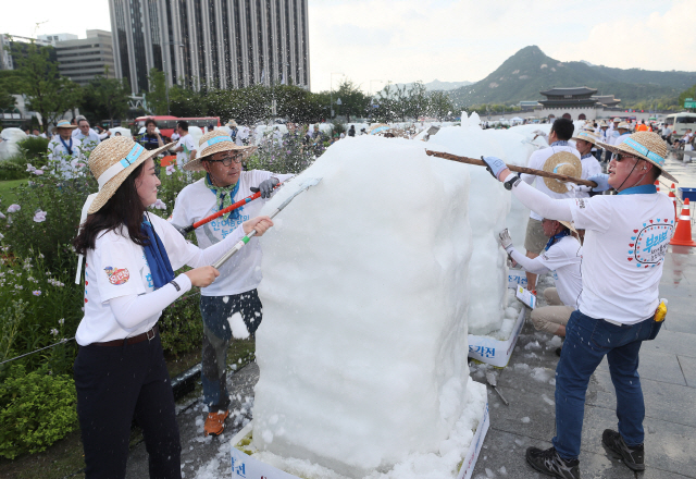 크라운해태 임직원들이 지난 10일 오후 서울 광화문 광장에서 ‘2019 한여름밤의 눈 조각전’에 사용할 작품들을 만들고 있다./연합뉴스