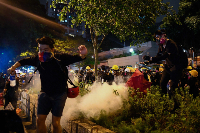 11일 홍콩 침사추이 지역에서 범죄인 인도 법안(일명 송환법) 반대 시위자들이 경찰이 쏜 최루탄 가스에 밀려나고 있다. /홍콩=AFP연합뉴스