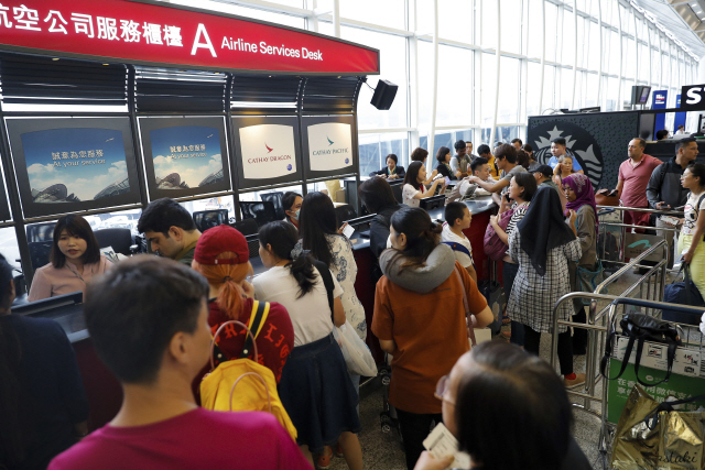 12일(현지시간) 오후 모든 항공편의 운항이 중단된 홍콩국제공항 체크인 카운터가 비행정보를 문의하려는 승객들로 북새통을 이루고 있다./홍콩=AP연합뉴스