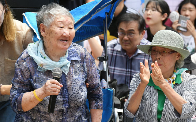 세계 일본군 위안부 기림일이자 74주년 광복절을 하루 앞둔 14일 서울 종로구 옛 주한일본대사관 앞에서 열린 ‘제1,400차 일본군 성노예제 문제해결을 위한 정기 수요시위’에 참석한 길원옥(왼쪽) 할머니가 인사하고 있다. 이날 수요쉬위는 국내 13개 도시를 비롯해 일본, 미국 등 해외 9개국 21개 도시에서 함께 개최됐다./오승현기자