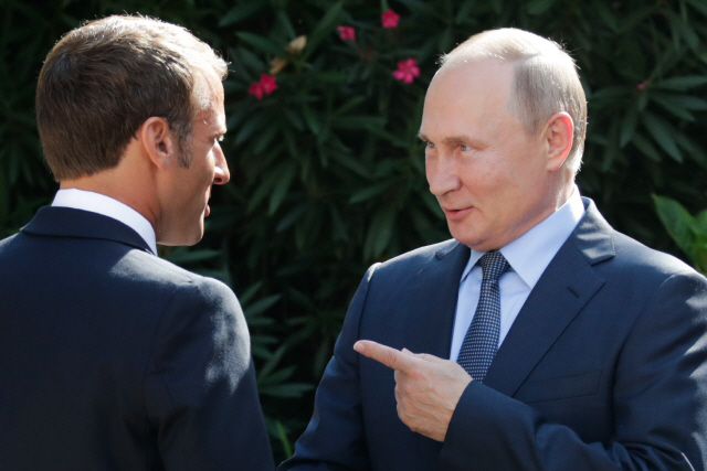 블라디미르 푸틴(오른쪽) 러시아 대통령과 에마뉘엘 마크롱(왼쪽) 프랑스 대통령이 19일(현지시간) 프랑스 봄레미모사의 브레강송 요새에서 정상회담에 앞서 이야기를 나누고 있다. /봄레미모사=타스연합뉴스