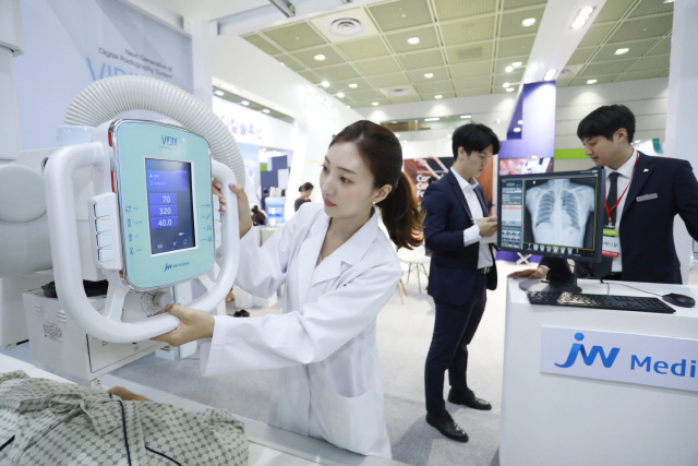 JW메디칼 직원이 21일 서울 삼성동 코엑스에서 열리는 국제병원의료기기산업박람회(K-Hospital Fair)에서 자체 기술로 개발한 국산 디지털 엑스레이 ‘비딕스 비(VIDIX B)’를 살펴보고 있다./사진제공=JW메디칼