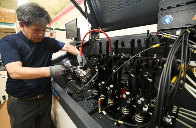 박임호 그린카프라 대표가 재제조된 인젝터와 고압 펌프의 성능을 테스트하고 있다. 재제조협회의 품질인증을 받은 제품은 ‘오토센’이라는 브랜드로 유통된다. /오승현기자