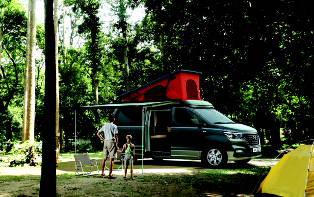 현대차의 스타렉스 캠핑카는 가족단위의 캠핑족들이 즐겨찾는 캠핑카 차종 중 하나다. 한 아버지와 아들이 캠핑카 앞에서 여유를 만끽하고 있다, /사진제공=현대차