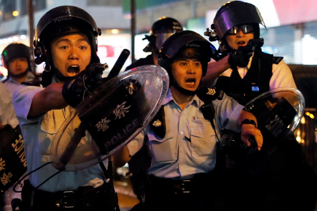홍콩 경찰이 25일(현지시간) 취안완 공원 인근에서 반정부 시위대의 공격을 받은 뒤 총을 꺼내 시위대를 겨두고 있다. /홍콩=로이터연합뉴스