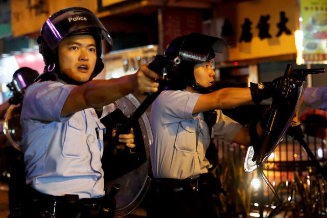 25일 저녁 홍콩경찰이 췬안 지역에서 시위대를 진압하는 과정에서 시위대를 향해 총을 겨누고 있다./REUTERS=연합뉴스