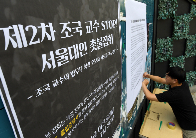 26일 서울대학교 총학생회 관계자가 조국 법무부 장관 후보자의 사퇴를 촉구하는 대자보를 게시판에 붙이고 있다./성형주기자 2019.08.26