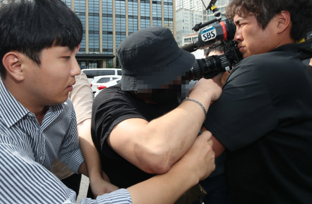‘홍대 일본 여성 폭행’ 동영상 속 가해자로 지목된 남성이 지난 24일 서울 마포경찰서에서 조사를 받고 나오던 중 취재진의 질문을 받고 있다. /연합뉴스