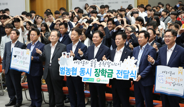 김병원(앞줄 오른쪽 네번째) 농협중앙회장이 26일 서울 중구 본사에서 열린 ‘범농협 동시 장학금 전달식’에서 임원 및 학생들과 기념촬영을 하고 있다. /연합뉴스