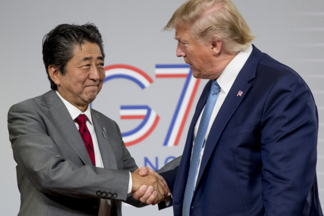 아베신조 일본 총리가 25일(현지시간) 프랑스 비아리츠에서 열리고 있는 G7 정상회의에 참석 중인 도널드 트럼프 미국 대통령과 악수를 나누고 있다./AP=연합뉴스