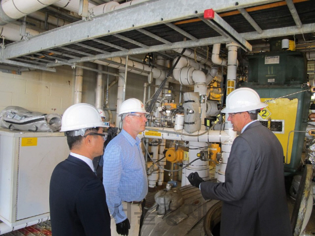 존 믈리나(가운데) 미국 미시건주 하원의원이 26일(현지시간) 스티브 퍼사인(오른쪽) SKSA 공장장으로부터 PVDC 생산 공정에 대한 설명을 듣고 있다. /사진제공=SK종합화학