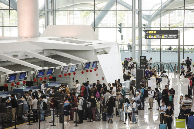 지난해 5월19일(현지시간) 관광객들이 광저우 바이윈국제공항 2터미널 체크인 카운터에서 줄 지어 기다리고 있다. /광저우=블룸버그