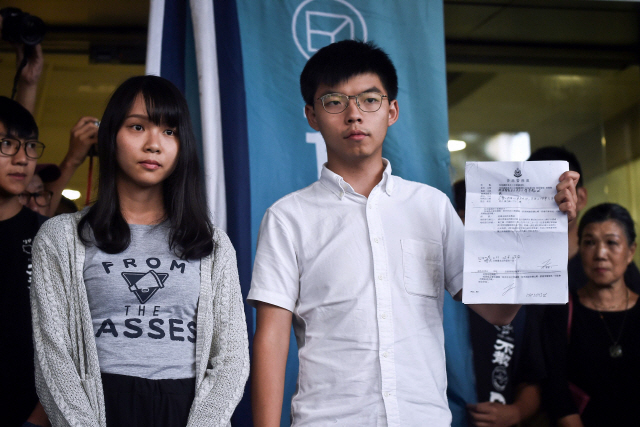 홍콩에서 ‘범죄인 인도 법안(송환법)’ 반대 시위를 이끌고 있는 조슈아 웡(오른쪽)과 아그네스 초우가 30일 오후 동부법원에서 보석으로 풀려나고 있다. 이들은 이날 오전 불법 집회 선동 및 참여 혐의로 경찰에 체포됐다. /홍콩=AFP연합뉴스