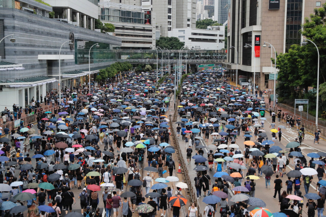 송환법에 반대하는 홍콩 시민들이 31일 홍콩 중심가 도로를 행진하고 있다. 이들은 검은 셔츠를 입고 우산을 편 채 행진을 벌였다. /홍콩=AP연합뉴스