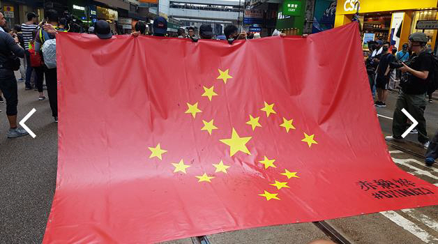 지난달 31일 송환법 반대 시위에 나온 시위 참가자들이 중국 오성홍기와 나치 문양을 결합해 만든 깃발을 들어보이고 있다. /연합뉴스