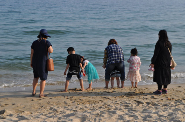 커즈앤컴퍼니에서 일하는 미혼모들이 아이들과 함께 바다를 바라보고 있다./사진제공=커즈앤컴퍼니