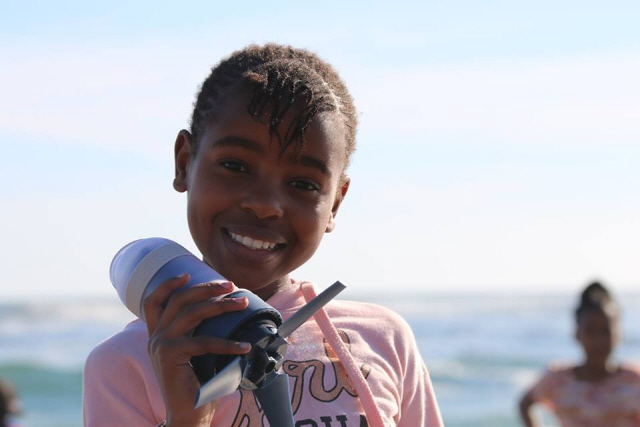아프리카 어린이가 국내 소셜 벤처 이노마드가 개발한 휴대용 수력발전기 ‘우노’를 들고 웃어 보이고 있다.  /사진제공=이노마드