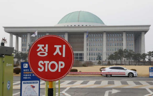 서울 여의도 국회의사당 앞에 마비된 국회 기능을 상징이라도 하듯 ‘정지(STOP)’ 안내판이 서 있다. 탄력근로 확대, 국민연금 개혁 등 핵심 정책이 서둘러 추진돼야 하는데 내년 총선 표심 탓에 겉돌고 있다.  /연합뉴스