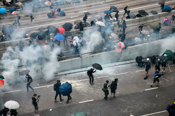 지난달 31일 홍콩 정부청사 인근에서 ‘송환법’에 반대하는 시민들이 경찰이 쏜 최루탄을 우산으로 막아가며 시위를 벌이고 있다./홍콩=AFP연합뉴스