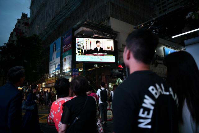 홍콩 시민들이 4일 오후 길거리에 설치된 대형 스크린을 통해 캐리 람 행정수반이 ‘범죄인 인도법안’(송환법) 공식 철회를 발표하는 모습을 지켜보고 있다.  /홍콩=AFP연합뉴스