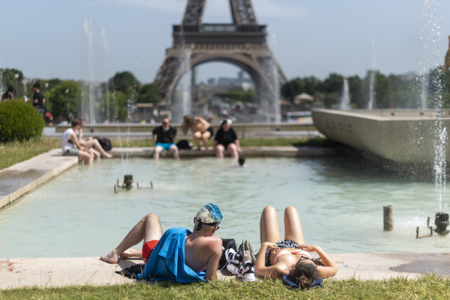 유럽에서 기록적인 폭염이 덮친 6월 28일(현지시간) 프랑스 파리 에펠탑 분수 앞에 사람들이 누워 더위를 식히고 있다. /파리=블룸버그