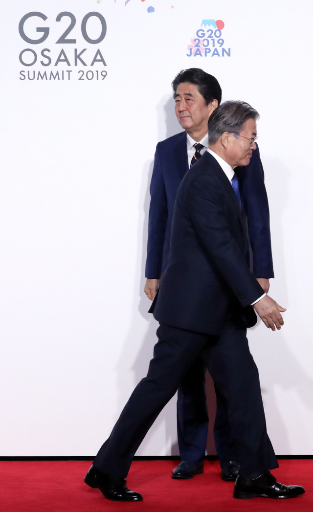 지난 6월 일본 오사카에서 열린 주요20개국(G20) 정상회의 공식 환영식에서 의장국인 일본의 아베 신조 총리와 악수한 뒤 문재인 대통령이 이동하고 있다. /연합뉴스