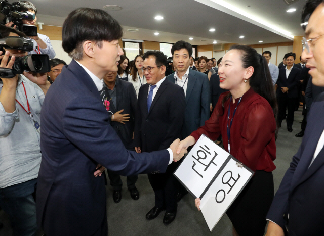 조국 신임 법무부 장관이 9일 정부과천청사 법무부에서 열린 취임식에서 취임사를 마친 뒤 ‘환영’ 팻말을 든 직원과 악수하고 있다. /과천=연합뉴스