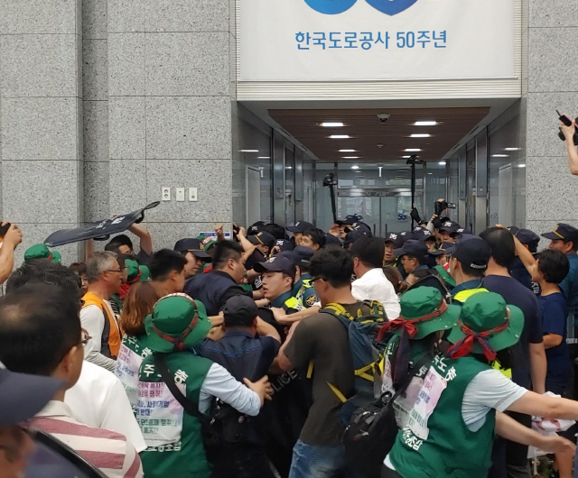 한국도로공사 톨게이트 요금 수납원들이 9일 경북 김천 도로공사 본사에서 직접 고용을 요구하며 건물 진입을 시도하고 있다./연합뉴스