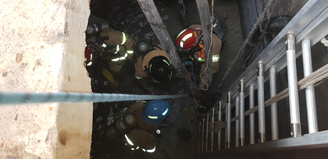 지난 10일 오후 2시 30분께 경북 영덕군 축산면 축산항 한 지하탱크에서 정비 작업 중이던 작업자 4명이 질식해 119 구급대원들이 구조를 하고 있다. /연합뉴스