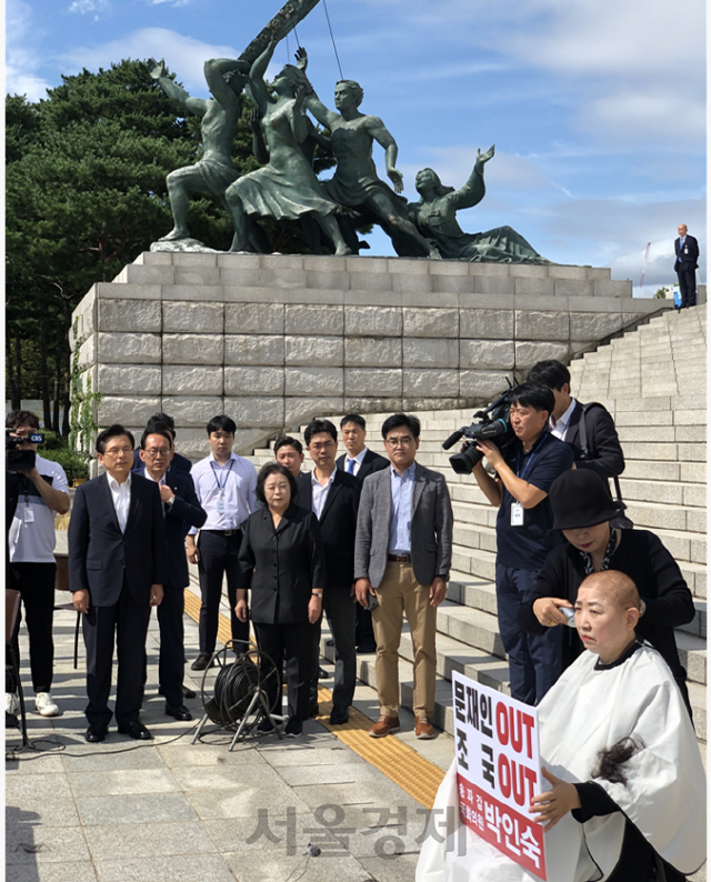박인숙(오른쪽) 자유한국당 의원이 11일 서울 여의도 국회 본청 계단 앞에서 조국 법무부 장관 사퇴를 촉구하며 삭발을 하며 눈시울을 붉히고 있다. 황교안(왼쪽 두번째) 한국당 대표는 이날 박 의원을 격려차 방문했다. /구경우기자