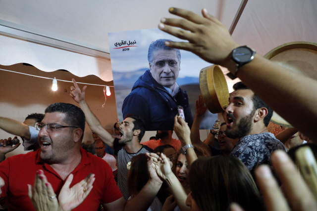 나빌 카루이 튀니지 대통령 후보 지지자들이 15일(현지시간) 투표가 종료된 후 출구조사 결과가 나오자 튀니스에 있는 선거 사무실 앞에 모여 환호하고 있다. /튀니스=EPA연합뉴스