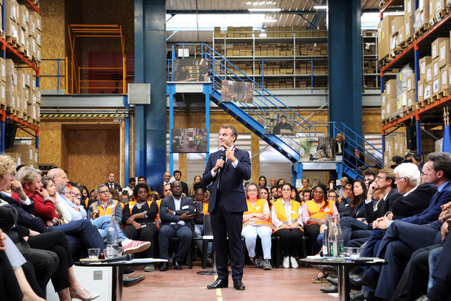 에마뉘엘 마크롱(가운데) 프랑스 대통령이 지난 10일(현지시간) 파리 인근에 위치한 실업자 재취업 지원기관 ‘국경 없는 워크숍’을 찾아 관계자 및 구직 중인 실업자들과 라운드테이블 미팅을 하고 있다.  /파리=EPA연합뉴스