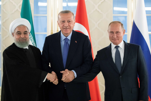 블라디미르 푸틴(오른쪽) 러시아 대통령과 하산 로하니(왼쪽) 이란 대통령, 레제프 타이이프 에르도안 터키 대통령이 16일(현지시간) 터키 앙카라에서 시리아 내전 종식을 위한 정상회담에 앞서 기념촬영을 하고 있다.  /앙카라=AFP연합뉴스