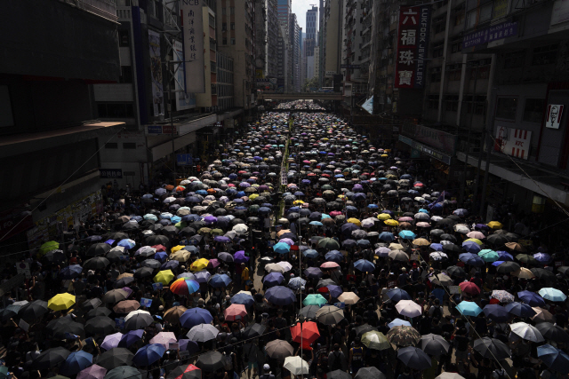 ‘범죄인 인도 법안’(송환법)에 반대하는 홍콩 시위대가 15일 경찰의 집회 금지에도 불구하고 우산을 쓴 채 도심을 행진하고 있다./홍콩 AP=연합뉴스