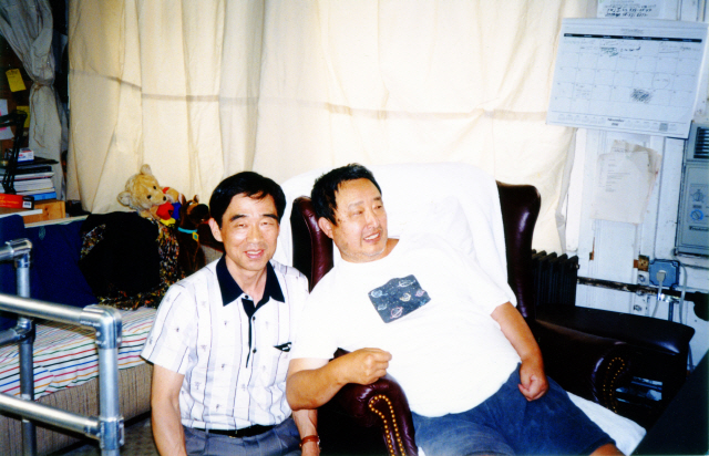 1996년 뇌졸중으로 쓰러진 후 휠체어 생활을 시작한 백남준(오른쪽)과 그의 기술조력자 이정성이 2003년 뉴욕 머서가의 백남준 자택에서 텔레비전을 시청하고 있다. /사진제공=이정성
