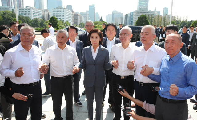 자유한국당 나경원 원내대표가 19일 국회 본청 앞에서 삭발을 마친 최교일, 백승주, 이만희, 장석춘, 김석기 의원들을 격려하고 있다. /연합뉴스