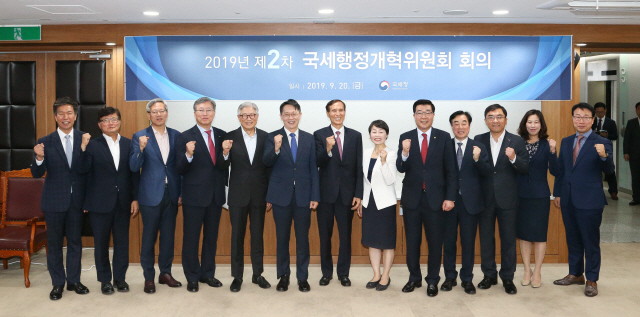 20일 제2차 국세행정개혁위원회에 참석한 김현준(왼쪽 여섯번째) 국세청장이 이필상(〃 일곱번째) 국세행정개혁위원장 및 위원들과 함께 민생경제 활력을 위한 세정지원을 다짐하며 파이팅을 외치고 있다. /사진제공=국세청