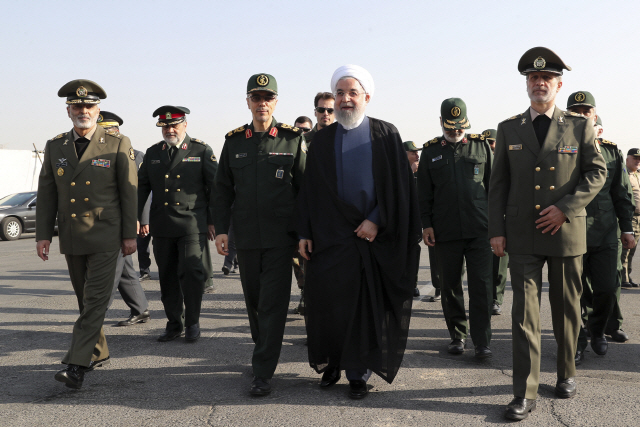 하산 로하니(가운데) 이란 대통령이 22일 이란-이라크전쟁 39주년을 기념해 테헤란에서 열린 이란군 퍼레이드 행사장에 도착해 군 사령관들과 함께 걸어가고 있다. /테헤란=AP연합뉴스
