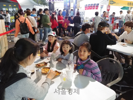 지난 21일 서울 서대문구 연세로에서 ‘제5회 신촌맥주축제’가 열리고 있는 가운데 가족들과 함께 축제 현장에 나온 어린이들이 길거리 음식을 먹으며 즐거워 하고 있다. /김정욱기자