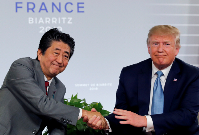 도널드 트럼프(오른쪽) 미국 대통령과 아베 신조 일본 총리가 지난달 25일(현지시간) 프랑스 비아리츠에서 열린 양자회담에서 악수하고 있다./비아리츠=로이터연합뉴스