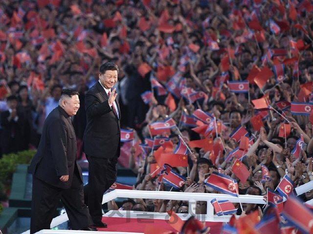 14년 만에 북한을 방문한 시진핑 중국 국가주석이 김정은 북한 국무위원장과 지난 6월20일 평양 능라도 5·1 경기장에서 무대에 오르고 있다./연합뉴스