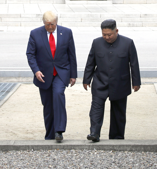 도널드 트럼프 미국 대통령과 김정은 북한 국무위원장이 지난 6월 30일 판문점에서 함께 군사분계선을 넘어 남측으로 넘어오고 있다. /판문점=연합뉴스