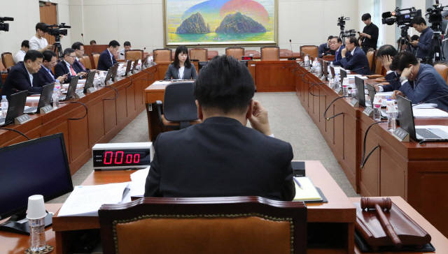 25일 국회에서 열린 정무위원회 전체회의에서 여야 의원들이 국감 증인 채택을 놓고 공방을 벌이자 민병두(뒷모습) 위원장이 난감해 하고 있다. /연합뉴스