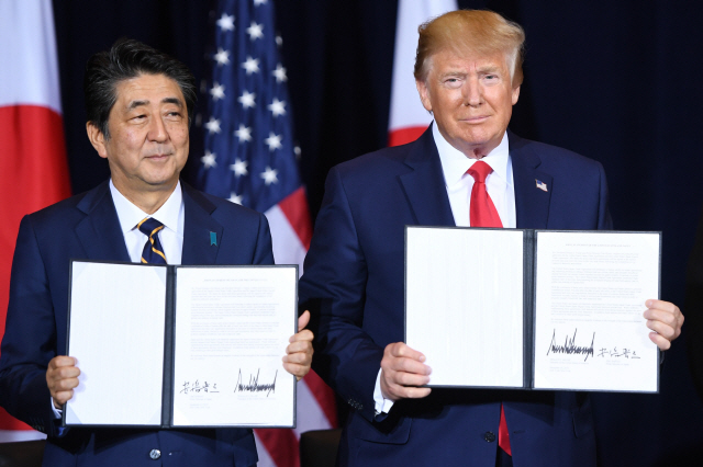 도널드 트럼프(오른쪽) 미국 대통령과 아베 신조 일본 총리가 25일(현지시간) 유엔총회가 열리고 있는 미 뉴욕에서 무역협정서에 서명한 뒤 들어보이고 있다. /뉴욕=AFP연합뉴스