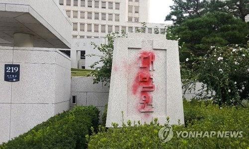 26일 오전 빨간 스프레이로 훼손된 대법원 청사 정문 대리석 표석 /연합뉴스