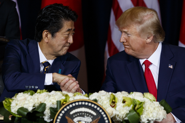 아베 신조(왼쪽) 일본 총리와 도널드 트럼프 미국 대통령이 25일(현지시간) 미국 뉴욕에서 무역협정 서명에 앞서 악수하고 있다./뉴욕=AP연합뉴스