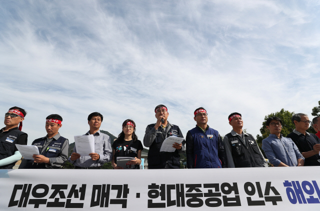 신상기(왼쪽 다섯번째) 민주노총 금속노조 대우조선지회장이 26일 서울 종로구 청와대 분수대 앞에서 현대중공업과 대우조선의 기업결합심사를 저지하기 위해 EU 경쟁총국을 직접 방문해 의견서를 전달하겠다는 기자회견을 하고 있다. /연합뉴스