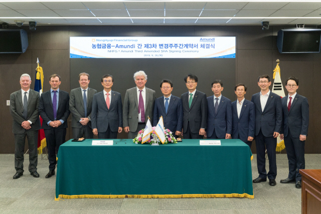 김광수(왼쪽 여섯번째) NH농협금융 회장이 26일 서울 중구 농협금융 본사에서 열린 ‘농협금융-아문디 간 제3차 변경주주간계약서 체결식’에서 이브 페리에(〃다섯번째) 아문디 회장을 포함한 양사 임직원들과 기념촬영을 하고 있다. /사진제공=NH농협금융