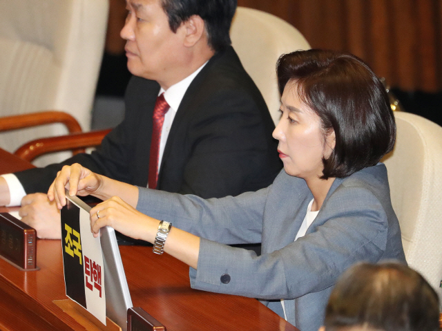 나경원 자유한국당 원내대표가 27일 오후 국회 본회의장에서 열린 외교·통일·안보 분야 대정부질문에 참석해 ‘조국 탄핵’이라고 적힌 종이를 모니터에 부착하고 있다.  /연합뉴스