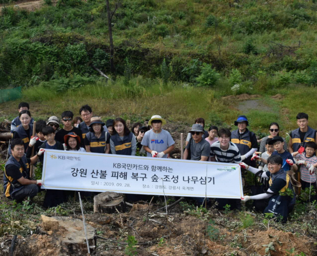 KB국민카드 임직원과 가족들이 28일 강원도 강릉시 옥계면 산불 피해지역에서 나무를 심고 기념촬영을 하고 있다. /사진제공=KB국민카드